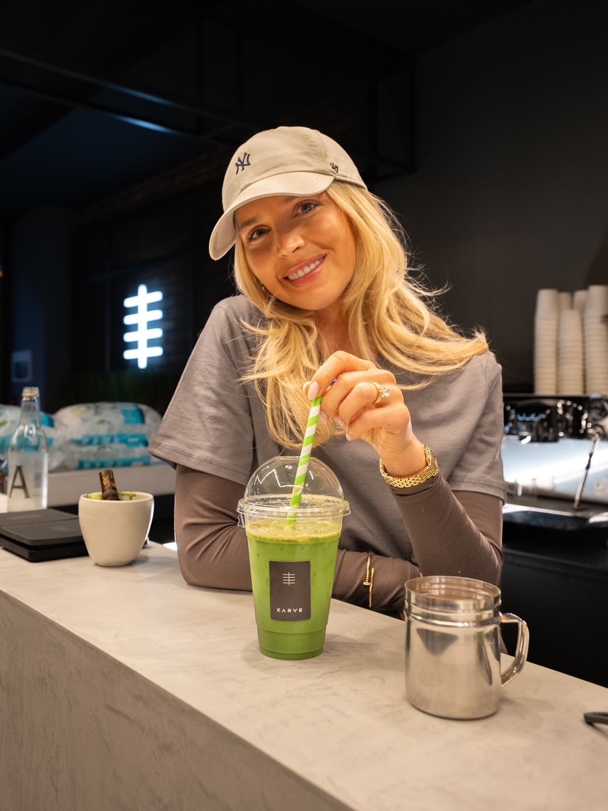 A guest stirring an iced matcha at the KARVE Café counter A guest stirring an iced matcha at the KARVE Café counter